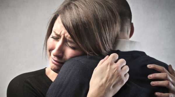 Женщина плачет и обнимает мужчину
