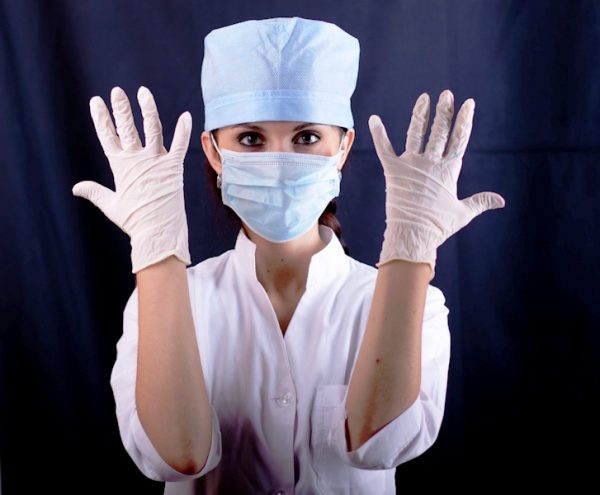 Девушка в перчатках, маске и медицинском халате